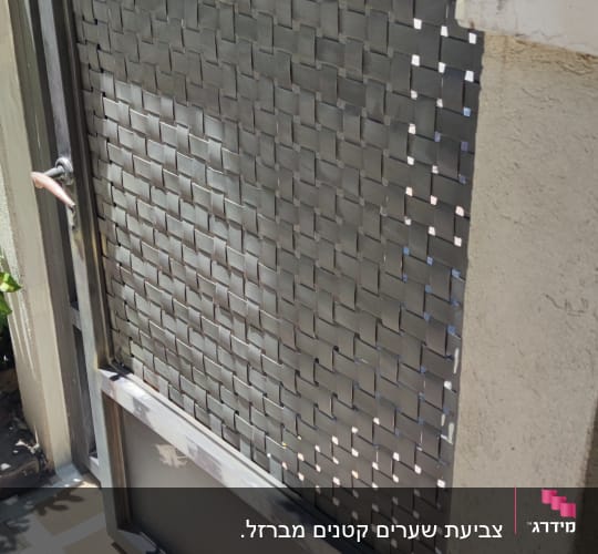 שער מתכת צבוע בצבע אפור עם קרטון מתחתיו